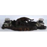 A 19TH CENTURY BAVARIAN BLACK FOREST INKWELL modelled with a roaming hound and foliage. 1Ft 3ins