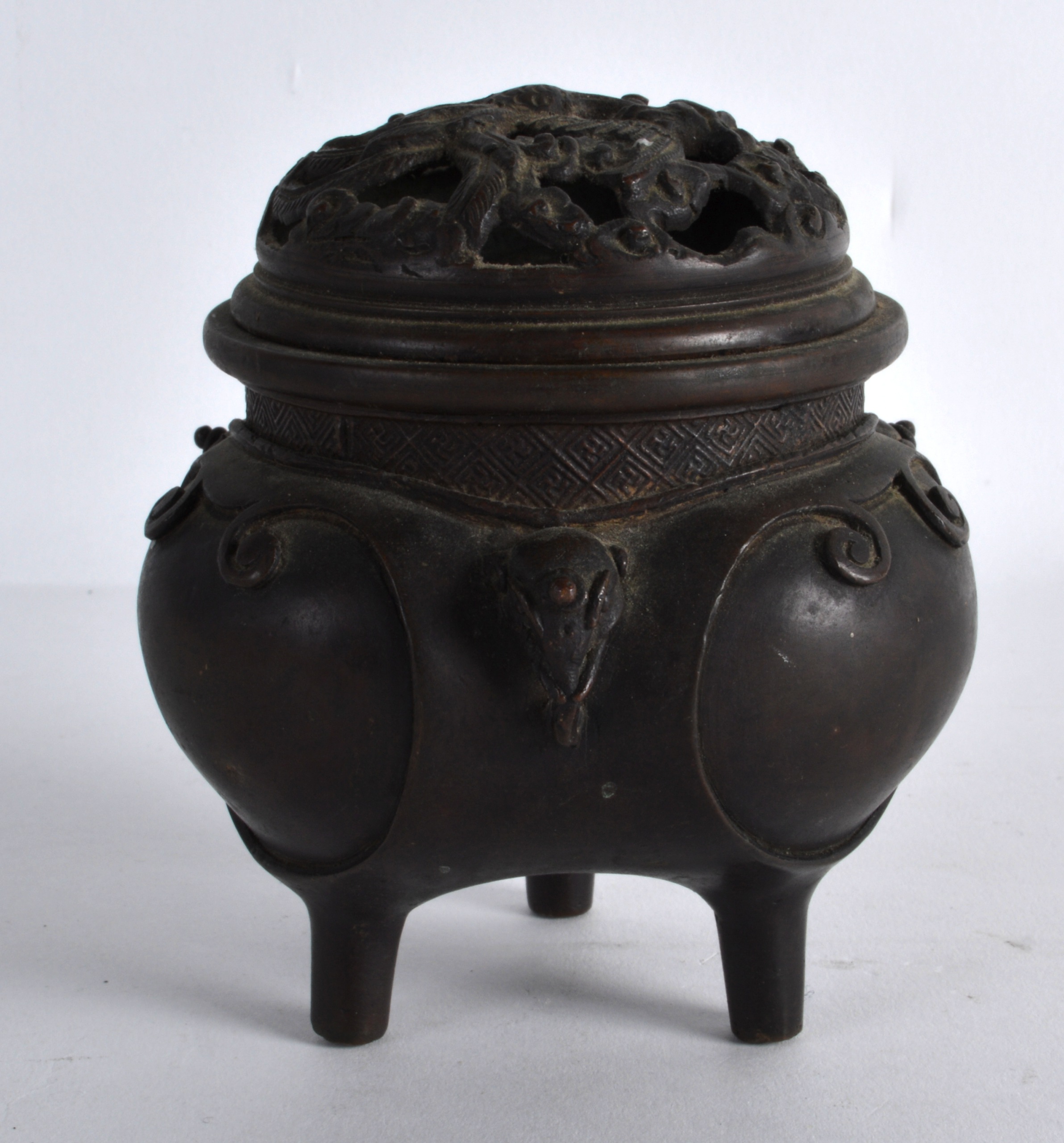 A 19TH CENTURY JAPANESE MEIJI PERIOD BRONZE CENSER AND COVER with mythical mask heads, the pierced