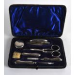 A LATE VICTORIAN/EDWARDIAN SILVER TRAVELLING SET containing a brush, button hook etc.