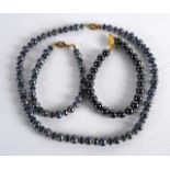 A BLACK PEARL NECKLACE and matching bracelet. (2)