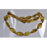 A CARVED YELLOW AMBER LADIES NECKLACE. 11Ins long.