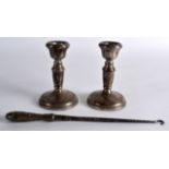 A SMALL PAIR OF HALLMARKED SILVER CANDLESTICKS together with a silver handled button hook. Candle