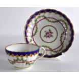 AN 18TH CENTURY WORCESTER TEACUP AND SAUCER painted in the Sevres style with a floral swag.