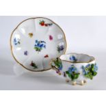 A 19TH CENTURY MEISSEN CUP AND SAUCER encrusted with flowers.