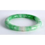 A FINE EARLY 20TH CENTURY CHINESE CARVED JADEITE BANGLE of lovely colour. 2.5ins diameter.