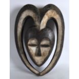 AN UNUSUAL CARVED AFRICAN TRIBAL MASK of stylish form. 1ft 2.5ins long.