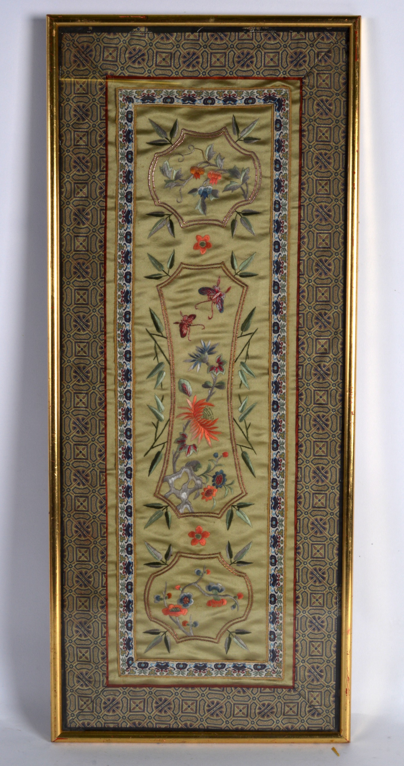 AN EARLY 20TH CENTURY FRAMED CHINESE SILKWORK PANEL decorated with flowers. 2ft 1ins x 10ins.