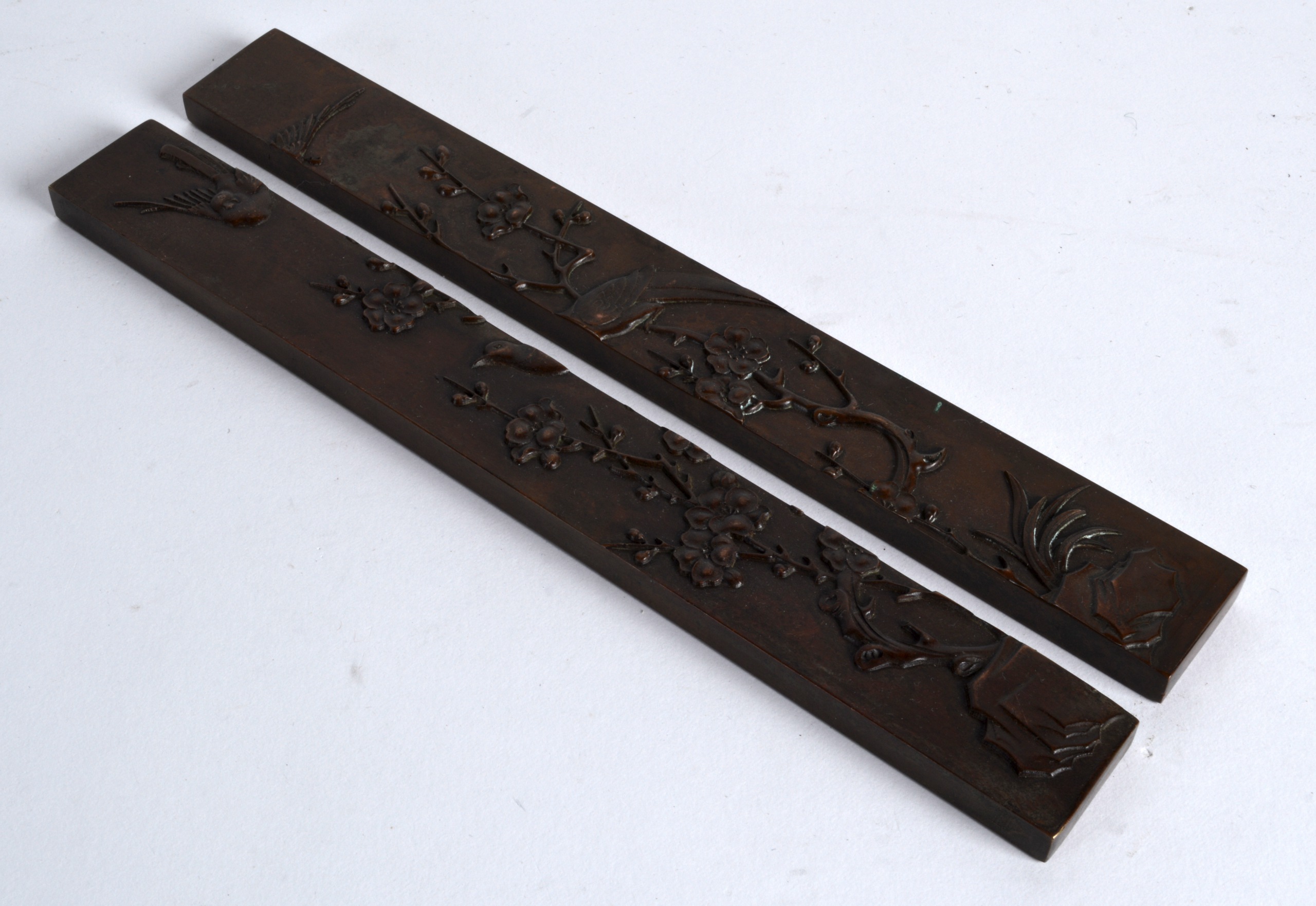 A PAIR OF CHINESE RECTANGULAR BRONZE SCROLL WEIGHTS decorated in relief with birds standing upon