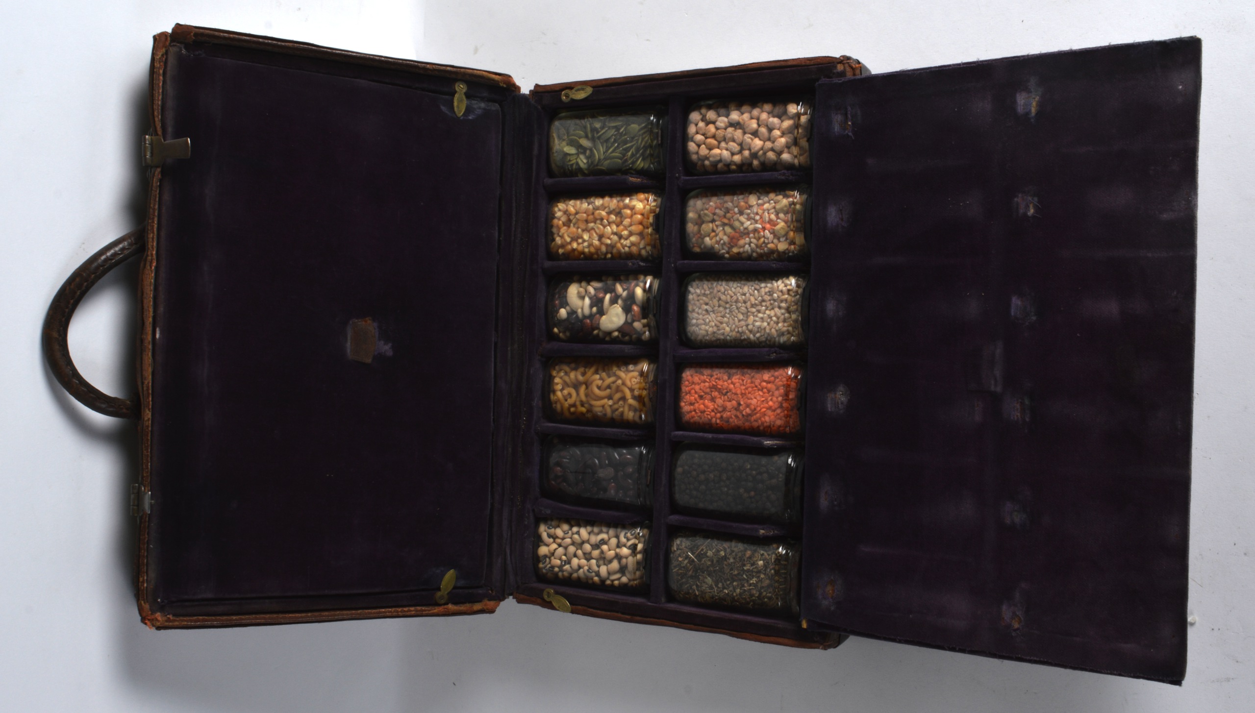 AN ANTIQUE LEATHER TRAVELLING SPICE CASE with some specimen jars still intact.