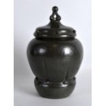 AN ARTS AND CRAFTS PEWTER JAR AND COVER with ridged body. 8.25ins high.