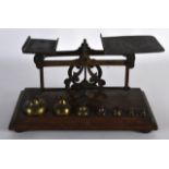 AN EARLY 20TH CENTURY OAK AND BRASS BOUND PAIR OF POSTAL SCALES with weights. 9.5ins wide.