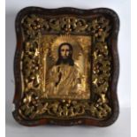 AN 18TH CENTURY RUSSIAN FRAMED PAINTED WOOD ICON contained within a gilt metal frame, then encased