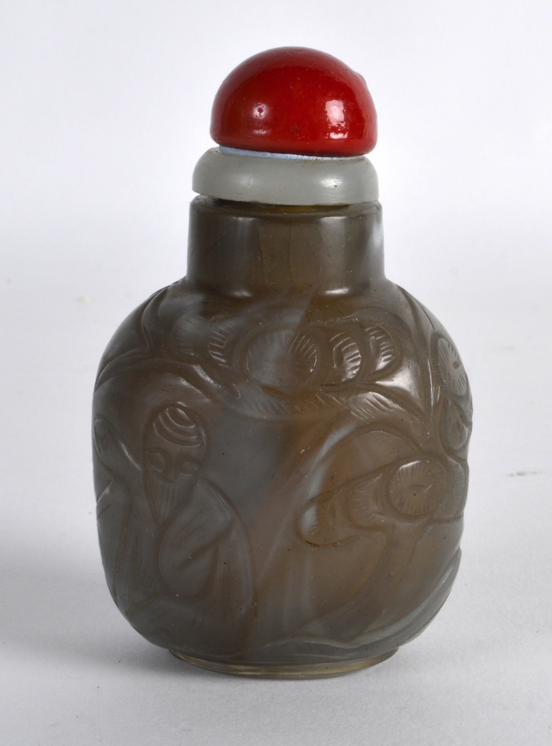 A 19TH CENTURY CHINESE CARVED AGATE SNUFF BOTTLE AND STOPPER decorated with a figure amongst