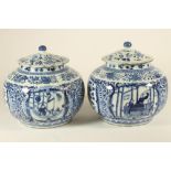A PAIR OF CHINESE PORCELAIN JARS AND COVERS of squat cylindrical form with sloping shoulders,