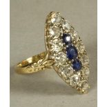 A SAPPHIRE AND DIAMOND DRESS RING, the three facet cut sapphires horizontally set within a border of