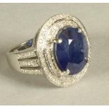 A SAPPHIRE AND DIAMOND CLUSTER RING, the oval cut sapphire of approximately 8cts claw set to a