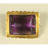 A VICTORIAN AMETHYST BROOCH, the oblong facet cut stone set to a plain 9ct gold mount