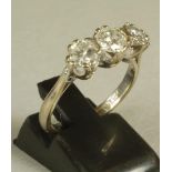 A THREE STONE DIAMOND RING, the central stone of approximately 0.50cts flanked by two similar