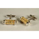 A PAIR OF SILVER DUMB BELL CUFFLINKS, pave set with numerous yellow and white sapphires