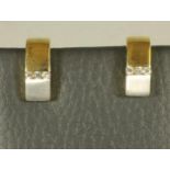A PAIR OF 9CT GOLD EAR STUDS, the white and yellow half hoops horizontally channel set with three