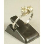 A TWO STONE DIAMOND CROSSOVER RING, the two brilliant cut stones of approximately 0.25cts, each claw