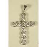 A DIAMOND CROSS PENDANT, the 18ct white gold frame open back collet set with eleven brilliant cut