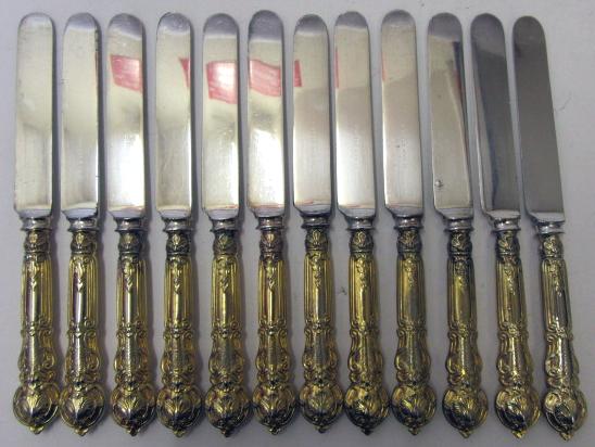 A SET OF TWENTY FOUR GOLD PLATED DESSERT KNIVES, c.1900, mainly Christofle with Gorham steel blades,