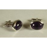 A PAIR OF SILVER CUFFLINKS, each open back collet set with an oval polished cabochon amethyst