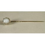 A STAR SAPPHIRE STICK PIN, the cabochon polished grey/blue stone claw set to an 18ct white gold rope