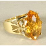 A CITRINE COCKTAIL RING, the facet cut marquise shaped stone claw set to open shoulders with diamond