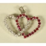 A RUBY AND DIAMOND ENTWINED HEART PENDANT, the stones claw set to an 18ct white gold frame with open