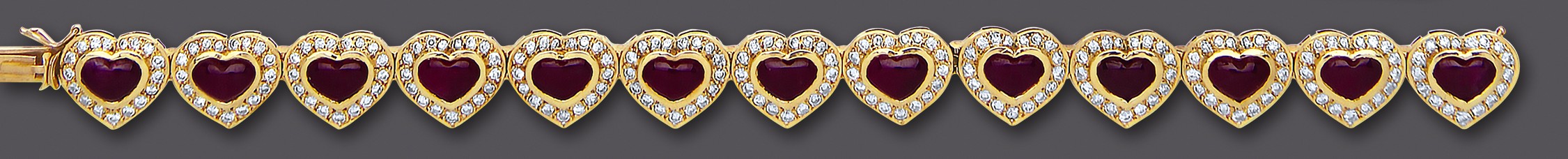 A RUBY AND DIAMOND BRACELET, the thirteen heart shaped links each centred by a polished heart shaped