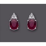 A PAIR OF RUBY AND DIAMOND EAR STUDS, the oval cut rubies of approximately 11cts claw set below a