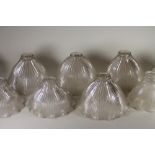 A SET OF FOUR HALOFLAME CLEAR GLASS LAMP SHADES of ribbed bell form with waved rim, stamped and