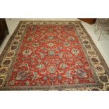 A PERSIAN STYLE RUG, modern, the red field with foliate scrolls and flowerheads in pale and navy