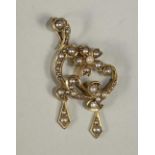 AN EDWARDIAN 15CT GOLD AND SEED PEARL PENDANT of asymetrical open scroll form with two drops