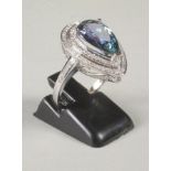 A TANZANITE AND DIAMOND CLUSTER RING, the pear cut tanzanite of approximately 3.84cts claw set to