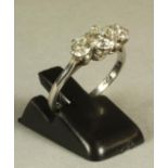 A THREE STONE DIAMOND RING, the central brilliant cut stone of approximately 0.70cts flanked by