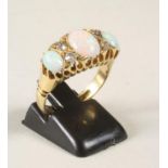 AN OPAL AND DIAMOND RING, the three oval cabochon polished opals interspersed with four old cut