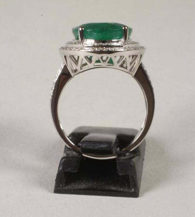 AN EMERALD AND DIAMOND CLUSTER RING, the oval cut emerald of approximately 8cts, claw set to a - Bild 2 aus 2