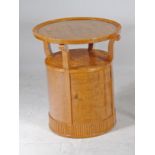 AN ART DECO MAPLE OCCASIONAL TABLE of circular form, the moulded edged top raised on four scrolled