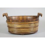 A STAVED FRUITWOOD BOWL, early 19th century, of oval tapering form, the lug handles carved as four