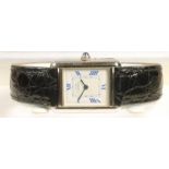 A LADY'S MUST DE CARTIER SILVER TANK WRISTWATCH, the white oblong dial with blue even Roman numerals