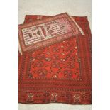 AN AFGHAN RUG, the red field with repeating multi gul pattern, within navy blue and ivory foliate