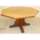 AN ADZED OAK DINING TABLE by Robert Thompson, the octagonal top with mildly concave sides, raised on