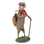 A STUFFED FOX, standing and dressed in a tweed flat cap, waist coat and plus fours, walking stick in