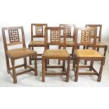 A SET OF SIX OAK DINING CHAIRS by Robert Thompson, the square tapering backs with pierced lattice