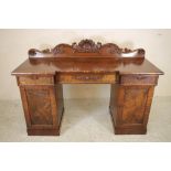 A WILLIAM IV MAHOGANY PEDESTAL SIDEBOARD, the inverted breakfront top with raised back carved with