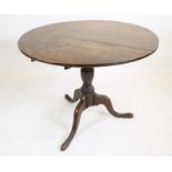 A GEORGIAN OAK TRIPOD TABLE, c.1770, the tip up circular plank top on turned vase stem, raised on