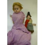 Two composition dolls comprising early 20th century doll with inset blue glass eyes, blonde mohair